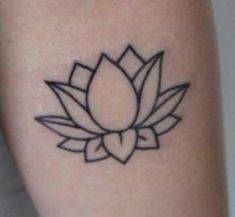 a small black and white lotus tattoo on the leg, with an arrow in the center