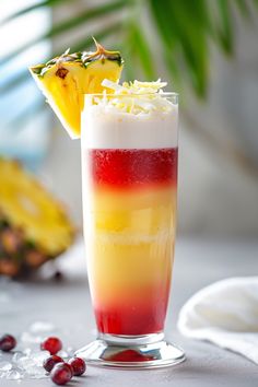 a colorful drink with pineapple and cranberry garnish