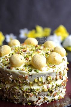 a cake with white frosting and pistachio toppings on a red plate