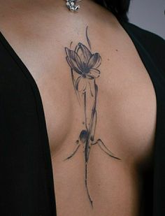 a woman with a flower tattoo on her back