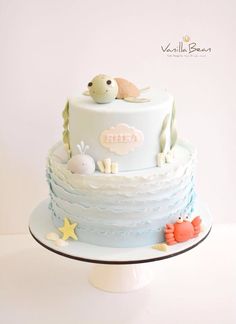 a blue and white cake with sea animals on it's top, sitting on a plate