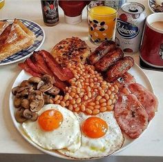 a breakfast plate with eggs, bacon, beans and toast