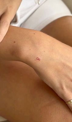 a woman's arm with a small tattoo on the left side of her leg