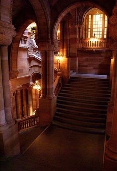 an old building with some stairs and lights in the dark night time, as seen from the second floor