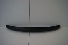 a black surfboard sitting on top of a white wall