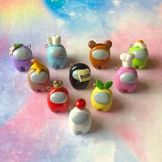 there are many small plastic toys on the table with watercolor paper in the background