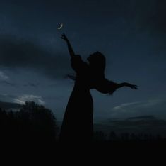 a woman reaching up to the sky at night