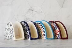 five ceramic dishes lined up on a marble counter