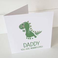 a greeting card with a green dinosaur on it's back and the words daddy you are roarsome