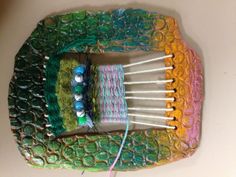 there are many knitting needles and yarn on top of each other in a basket that is made out of plastic