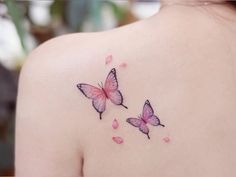 two pink butterflies on the back of a woman's shoulder