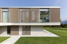 a modern house with wooden slats on the front and side walls, in an open field