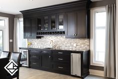 a kitchen with black cabinets and stainless steel appliances