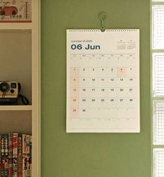 a calendar hangs on the wall next to books