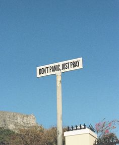 a street sign that reads don't panic, just pray on top of it