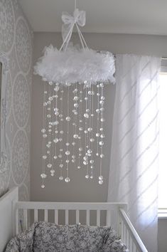 a white crib with a chandelier hanging from the ceiling