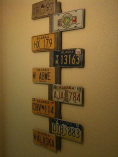 a pole with many different license plates mounted to it's sides and hanging on the wall