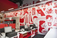 the interior of a computer store with red and white wallpaper