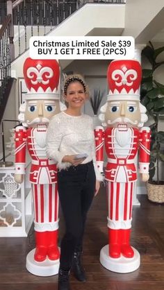 a woman standing next to two large nutcrackers