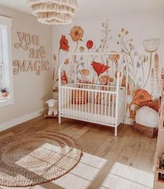 a baby's room with flowers painted on the wall and a crib in the foreground