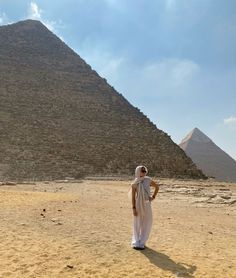 a woman standing in front of the great pyramid