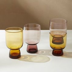 three different colored glasses sitting on top of a table