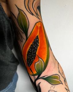 a woman with a tattoo on her arm has a piece of fruit in the shape of a flower