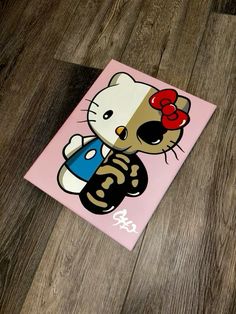 a hello kitty sticker is on the floor next to a wooden floor with a pink background