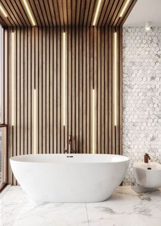 a large white bath tub sitting next to a wall with wooden slats on it