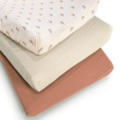 three mattresses stacked on top of each other in different colors and sizes, one with a pink bottom