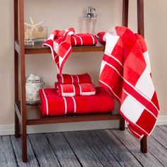 red towels are stacked on a shelf in the bathroom