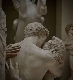 two statues are hugging each other in the middle of a room