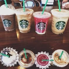 starbucks drinks lined up on a table with green straws in each cup and two for the other