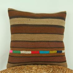 a striped pillow sitting on top of a straw hat