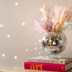 a disco ball sitting on top of a stack of books next to a mirror ball