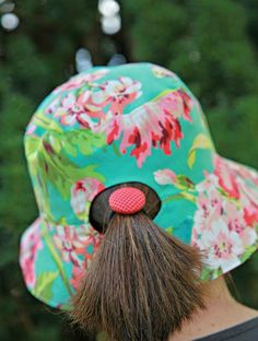 a man with a flowered hat has a fake moustache on his head