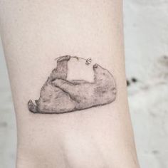 a black and white photo of a bear tattoo on the ankle by kottotatto studio