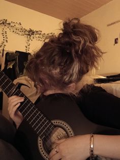 a woman is playing an ukulele in her living room