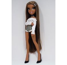 a black and white doll with long brown hair wearing a white shirt and striped skirt