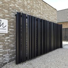 a brick building with a black metal fence next to it and a sign on the wall