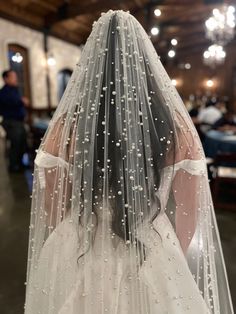 the back of a bride's veil with pearls on it