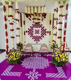 a decorated stage with chairs and flowers on the floor for a wedding ceremony or reception