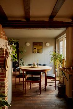 a dining room with a table and chairs next to a fire place in front of a brick wall