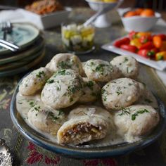 a plate full of food sitting on a table next to plates and silver wares