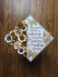 a graduation cap decorated with flowers on top of a wooden floor