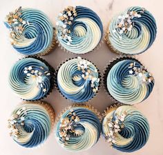 blue and white cupcakes with sprinkles arranged on a marble surface