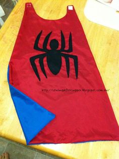 a red spiderman shirt with blue triangles on the table next to it is a napkin