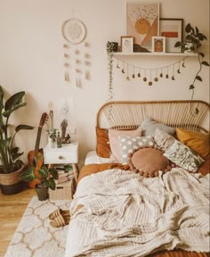 a bedroom with a bed, plants and pictures on the wall