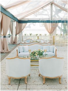 a living room with couches and chairs in front of a white tented area