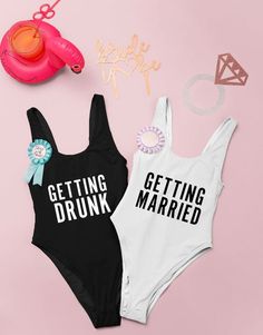 two black and white swimsuits that say let's get nautity